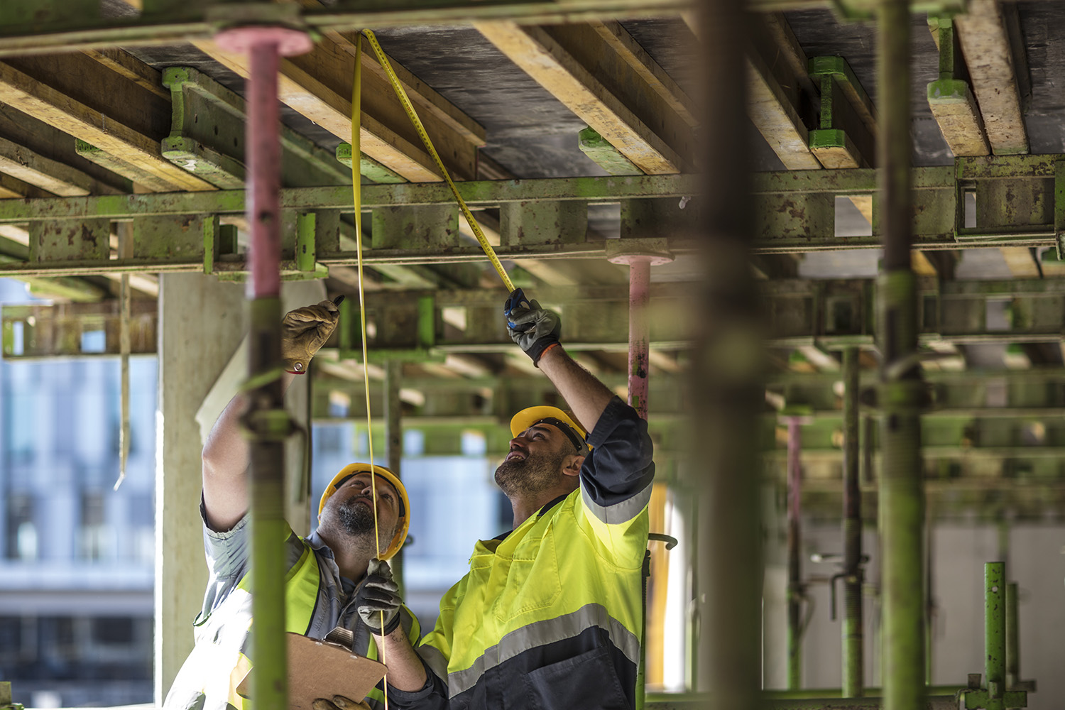 Construction workers planning and measuring
